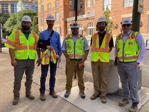 Group of five construction workers wearing safety equipment.